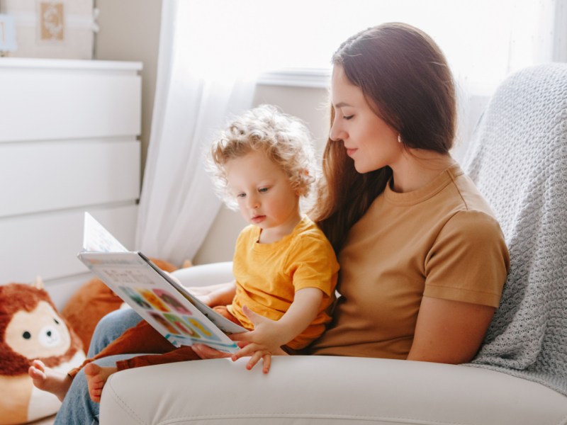 Mama liest Buch mit Baby Junge Kleinkind zu Hause.