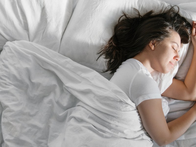 Frau liegt im Bett und schläft.