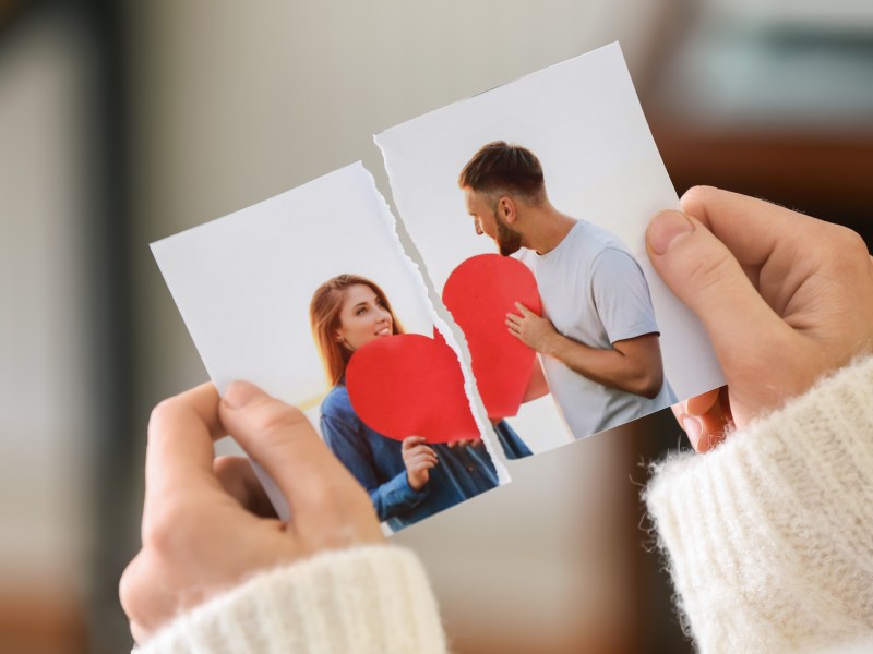 Person hält zerrissenes Pärchenfoto in der Hand