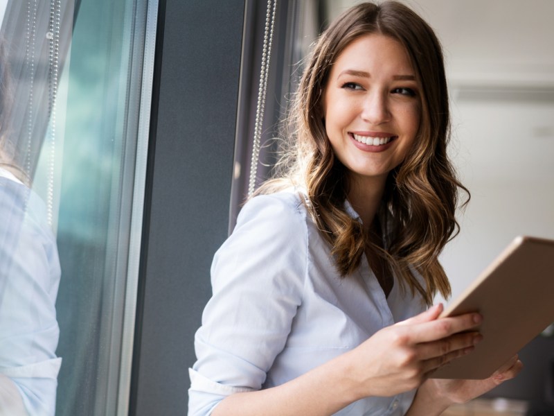 Frau mit tollen Job-Sternen steht mit einem Ipad auf der Arbeit.