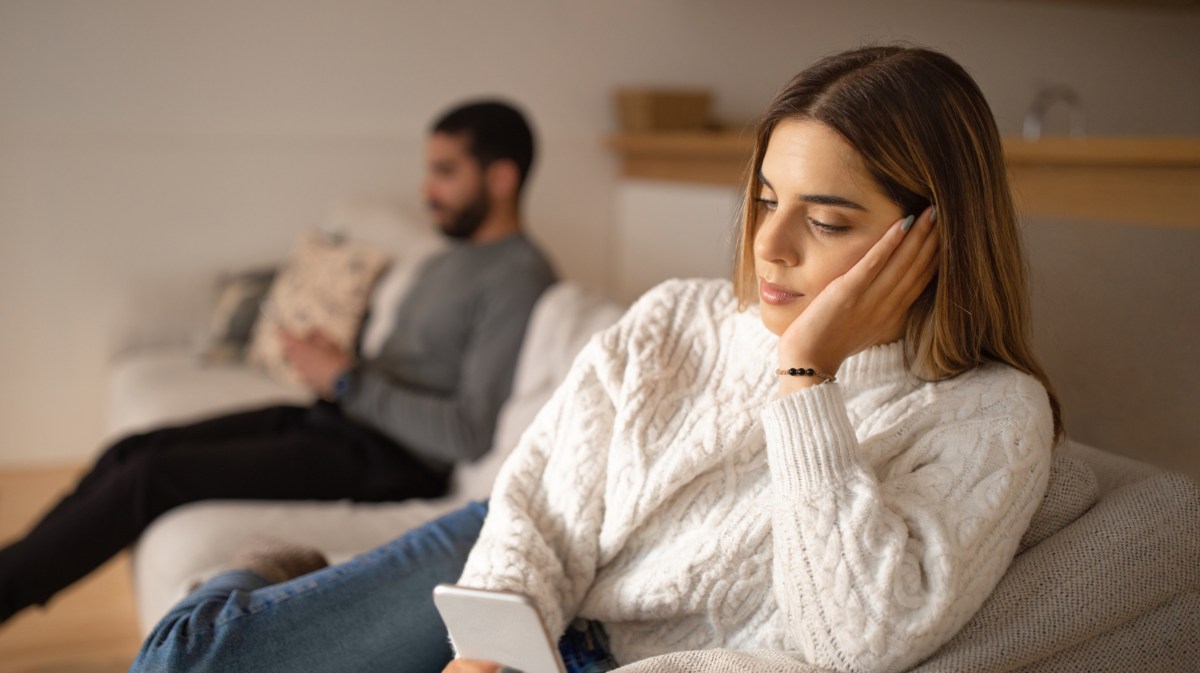 Frau guckt bedrückt ins Smartphone