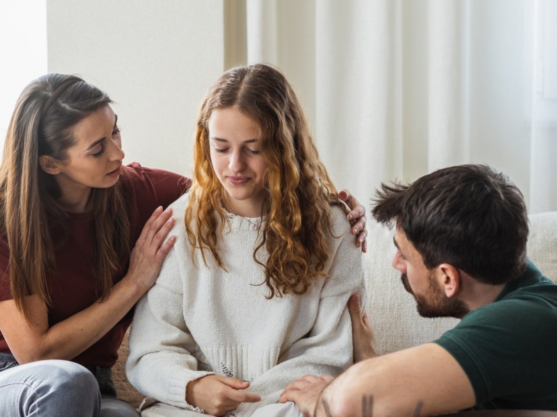 Drei Freunde, die Mitgefühl zeigen und Frau trösten