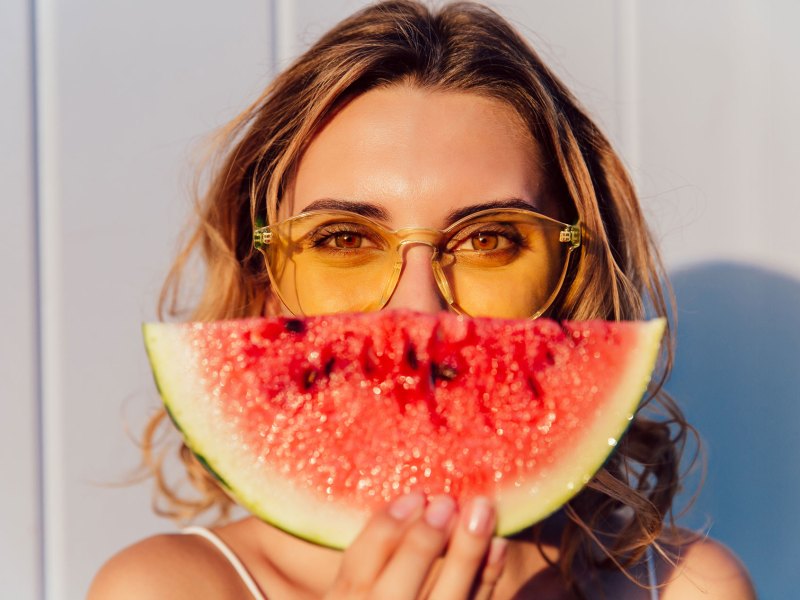 Frau mit Wassermelone und lackierten Fingernägeln.