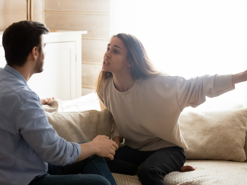 Paar, das sich auf Couch anschreit und streitet