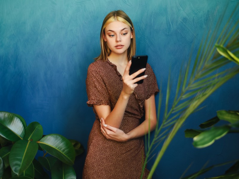 Frau schaut ernst auf ihr Smartphone