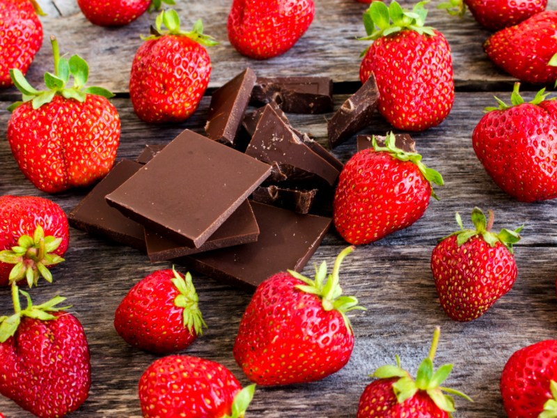 Erdbeeren und Schokolade auf einem Holztisch