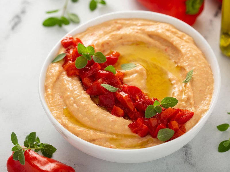 Paprika-Dip mit Paprikastücken dekoriert