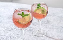 Sarti Spritz: Hellrosa Getr&auml;nk in Weingl&auml;sern mit Limettenscheiben