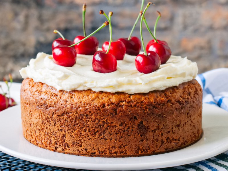 Kuchen mit Sahnehaube und Kirschen.