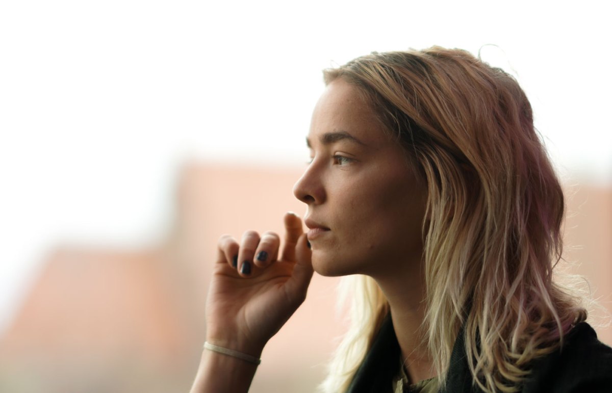 Frau blickt ernst aus dem Fenster
