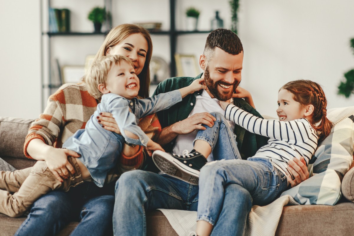 Vater und Mutter mit ihren zwei Kindern haben Spaß.