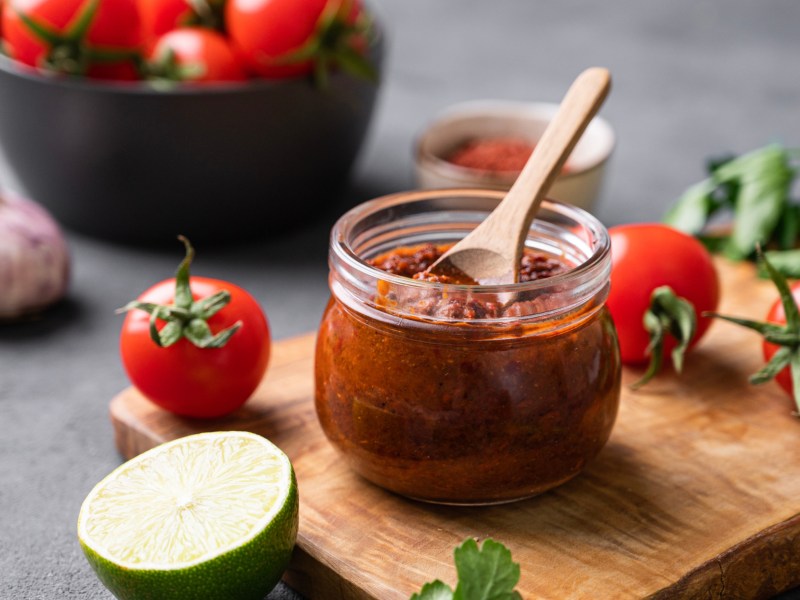 Harissa-Dip mit Tomaten, Limette und Koriander im Hintergrund