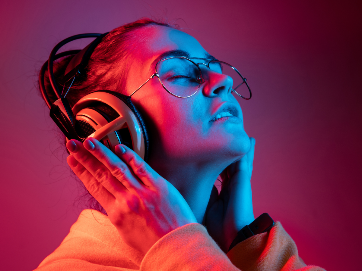 Frau mit Kopfhörern vor rotem Hintergrund