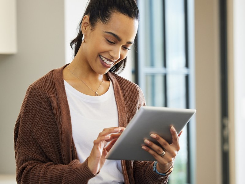 Frau hält ein Tablet in der Hand.