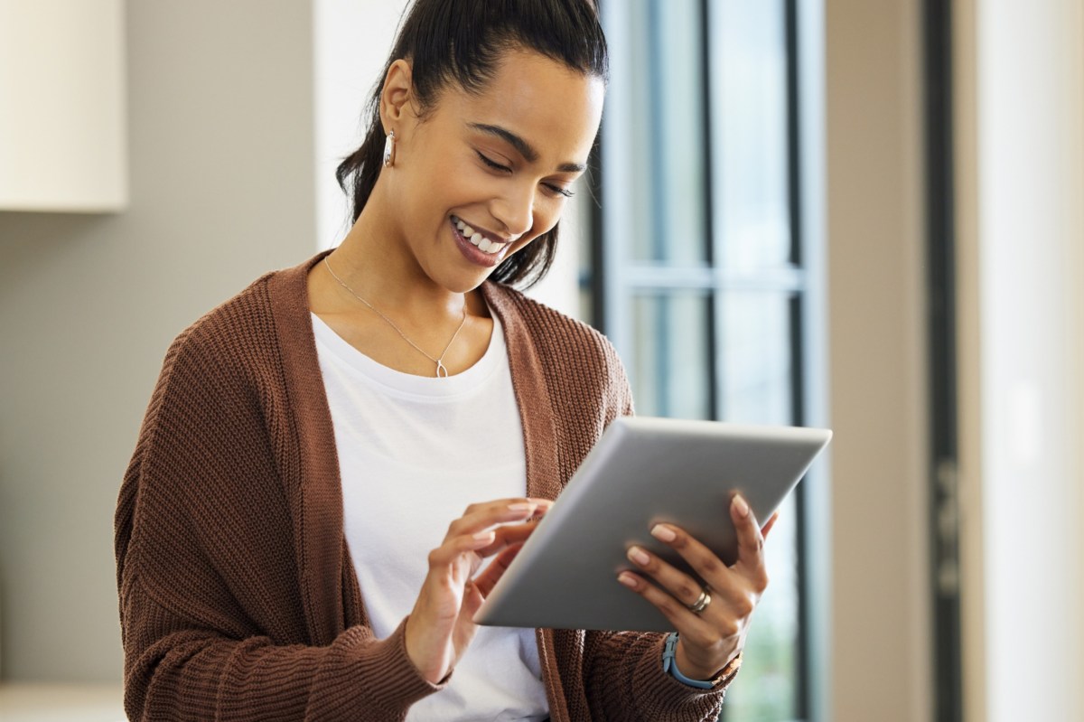 Frau hält ein Tablet in der Hand.