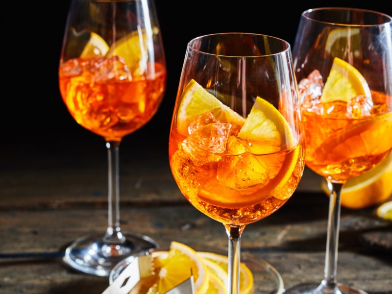 Aperol Getränk mit Eiswürfel und Orangenscheiben.