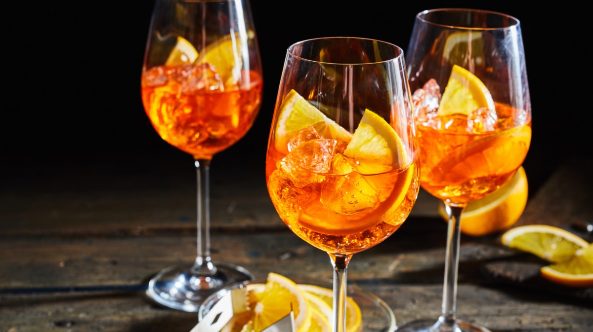 Aperol Getränk mit Eiswürfel und Orangenscheiben.