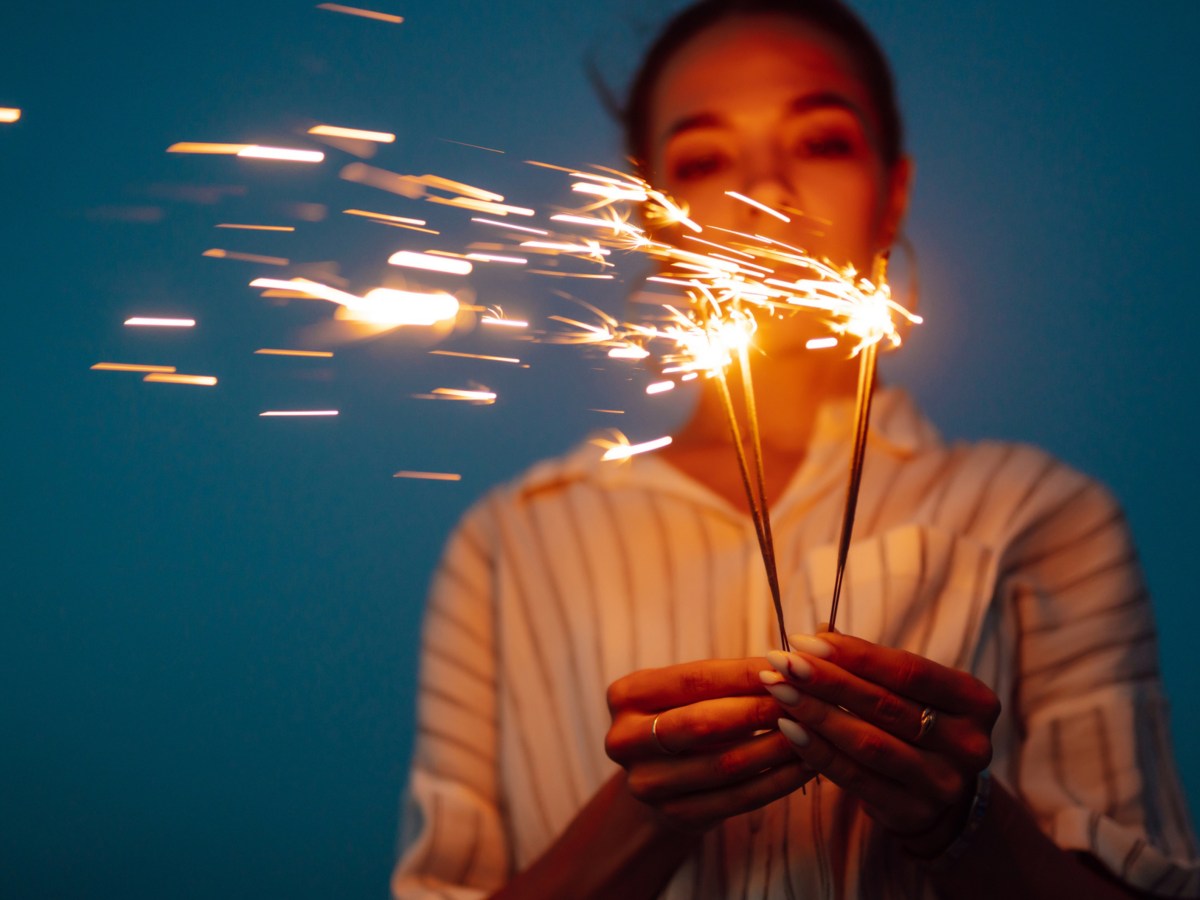 Frau h&auml;lt Wunderkerzen in Hand.