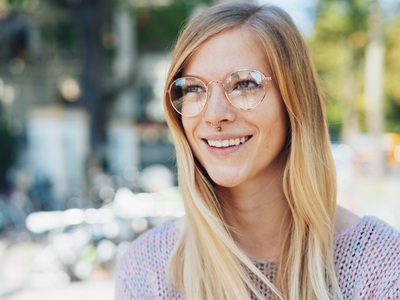 Frau mit Brille lächelt.