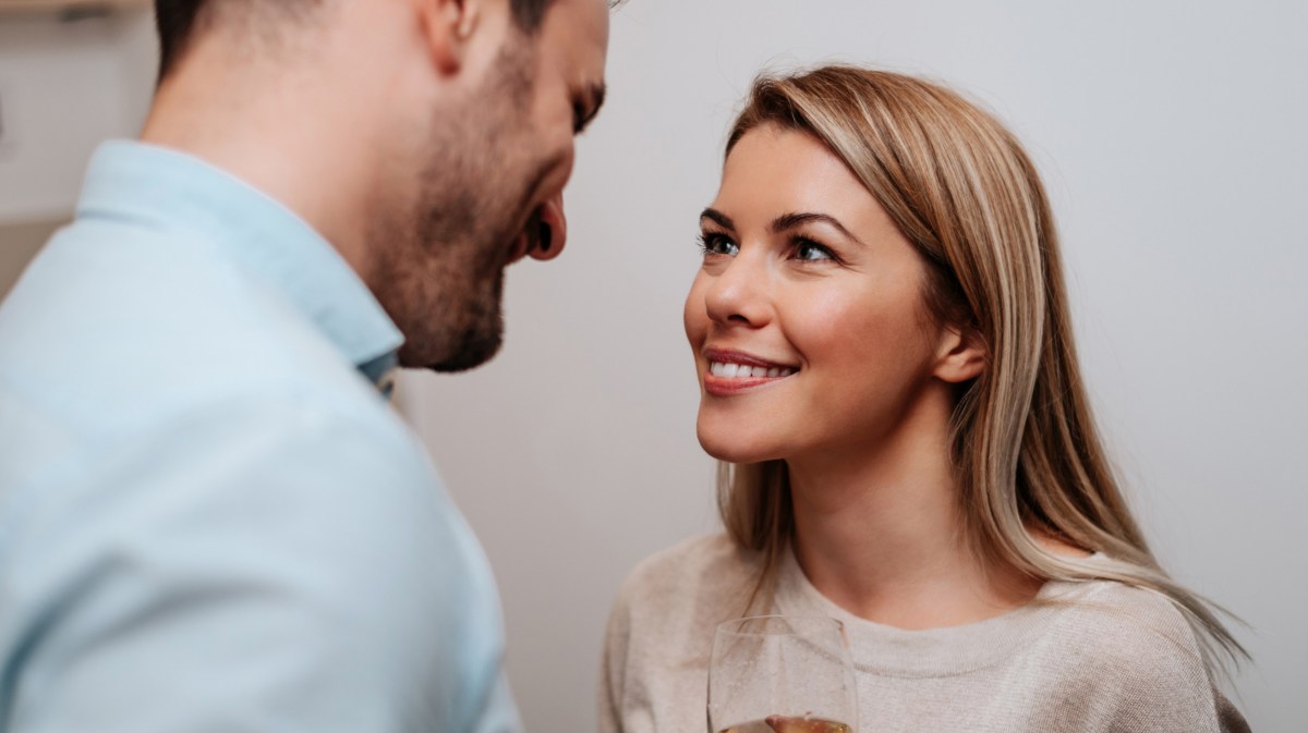 Blonde Frau schaut lächelnd zu Mann hoch.