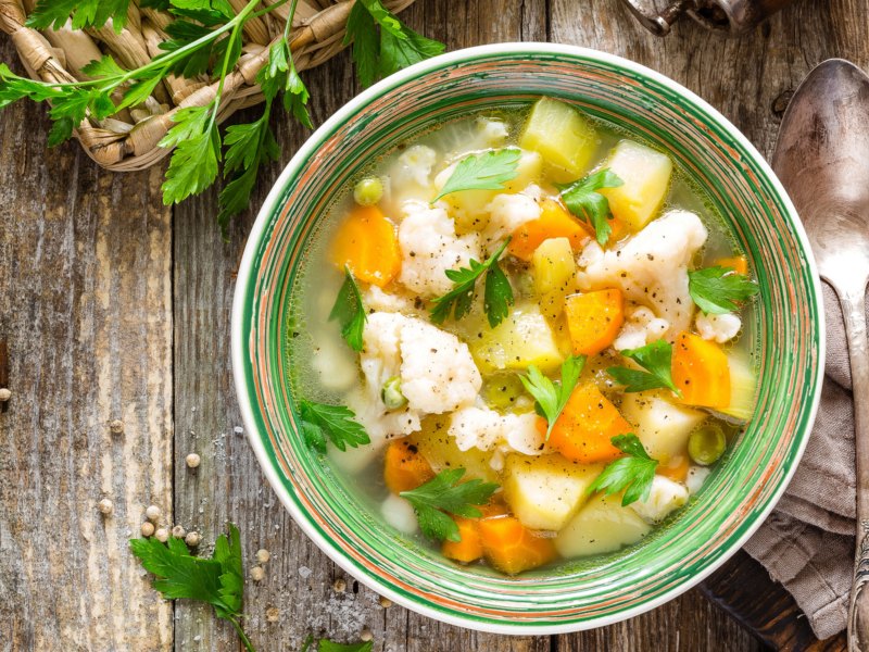 Gemüsesuppe in grüner Schüssel.