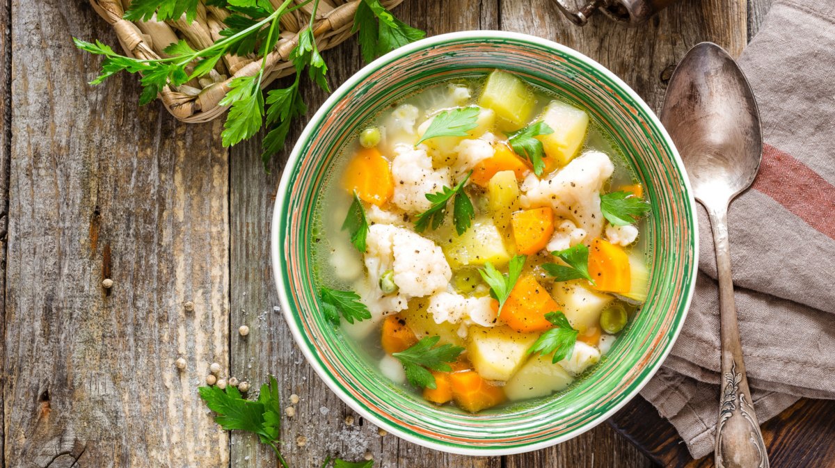 Gemüsesuppe in grüner Schüssel.