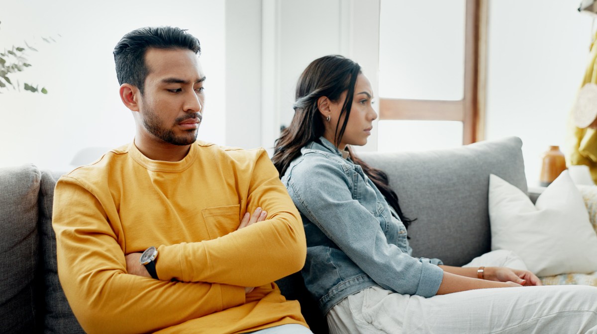 Wütendes Pärchen sitzt auf Sofa.