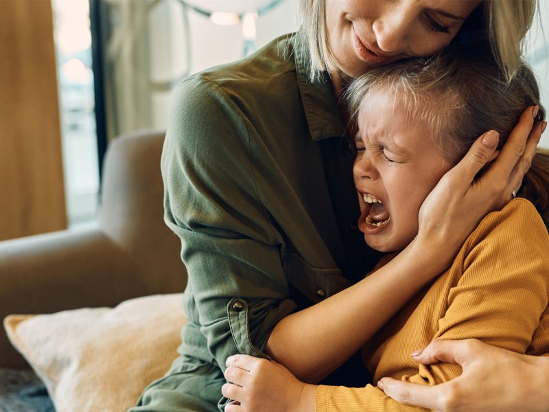 Mutter tröstet ihre schreiende und weinende Tochter.