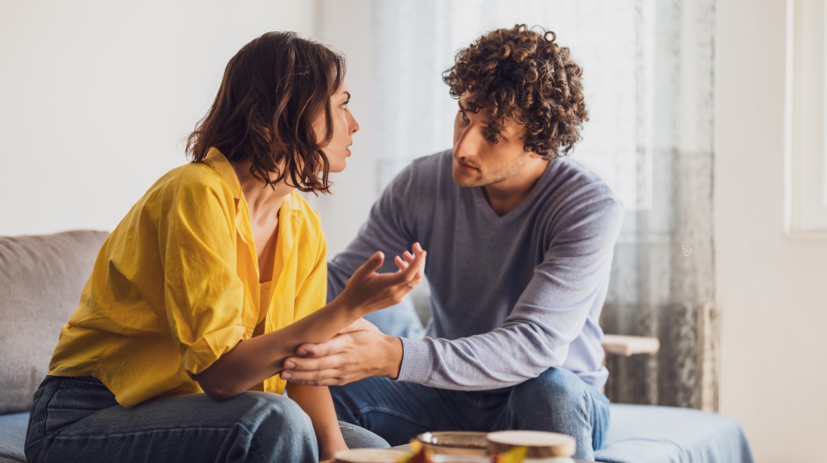 Frau und Mann auf einem Sofa, die miteinander diskutieren