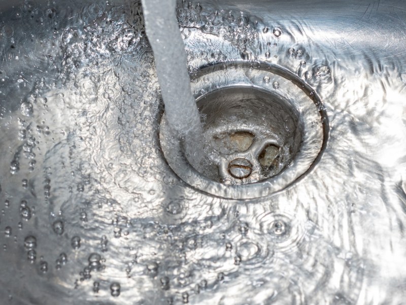 Wasser läuft einen Abfluss herunter.