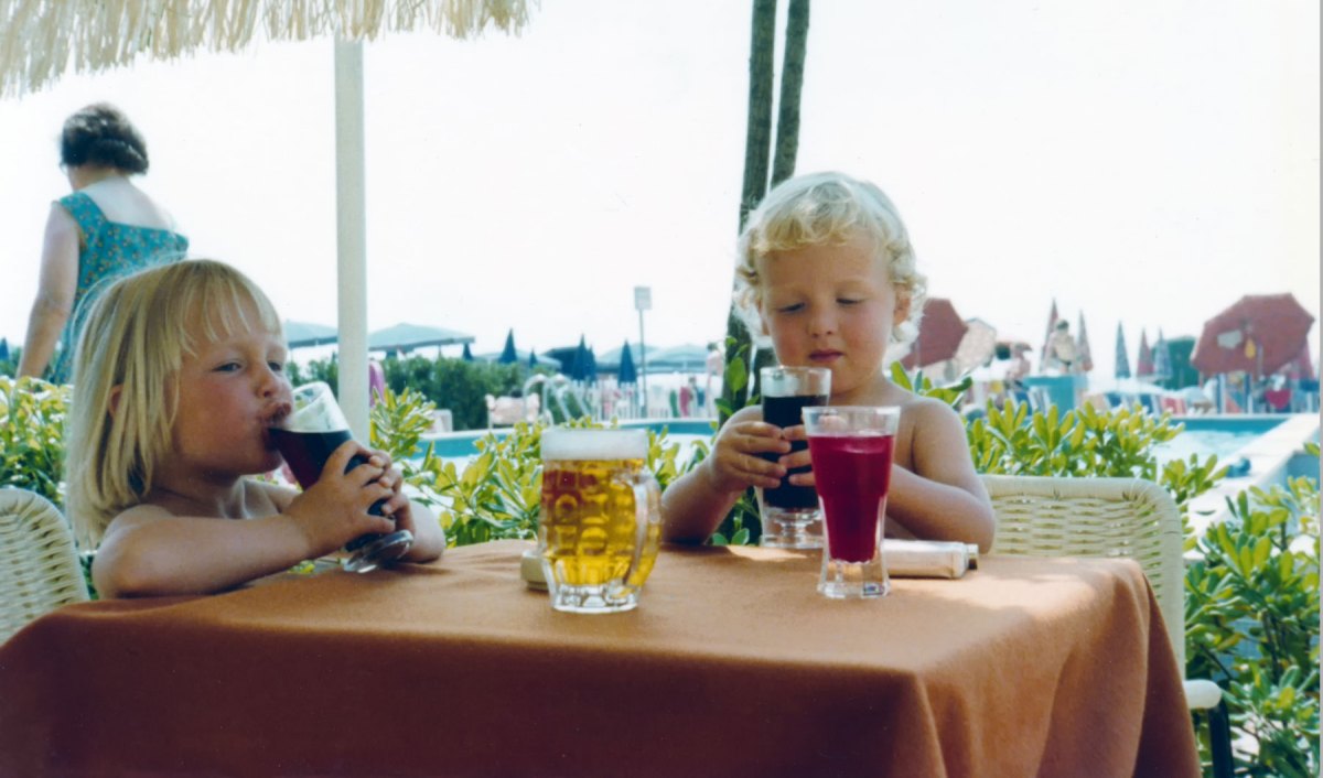 Ein Bild von zwei Kindern an einem Tisch mit Cola Gläsern, geschossen in den 80er Jahren.