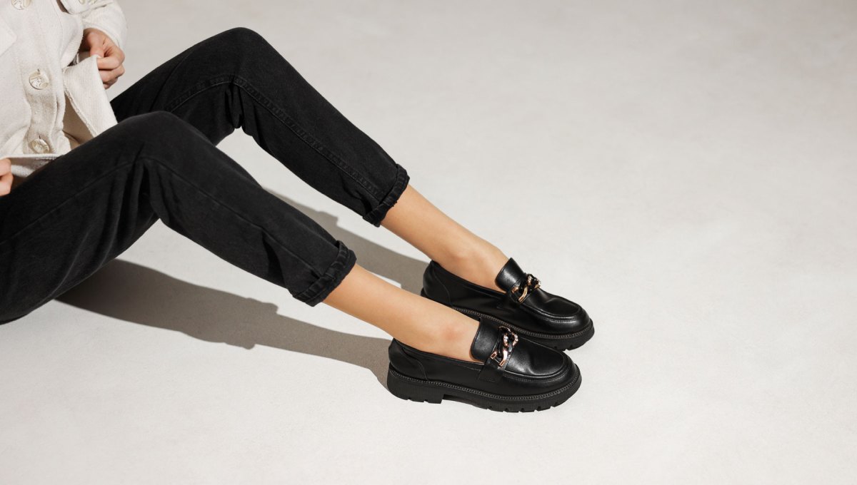 Frauenbeine in schwarzen Loafer