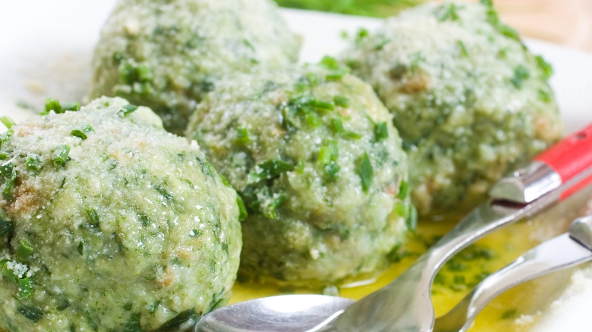 Spinatknödel auf weißem Teller.