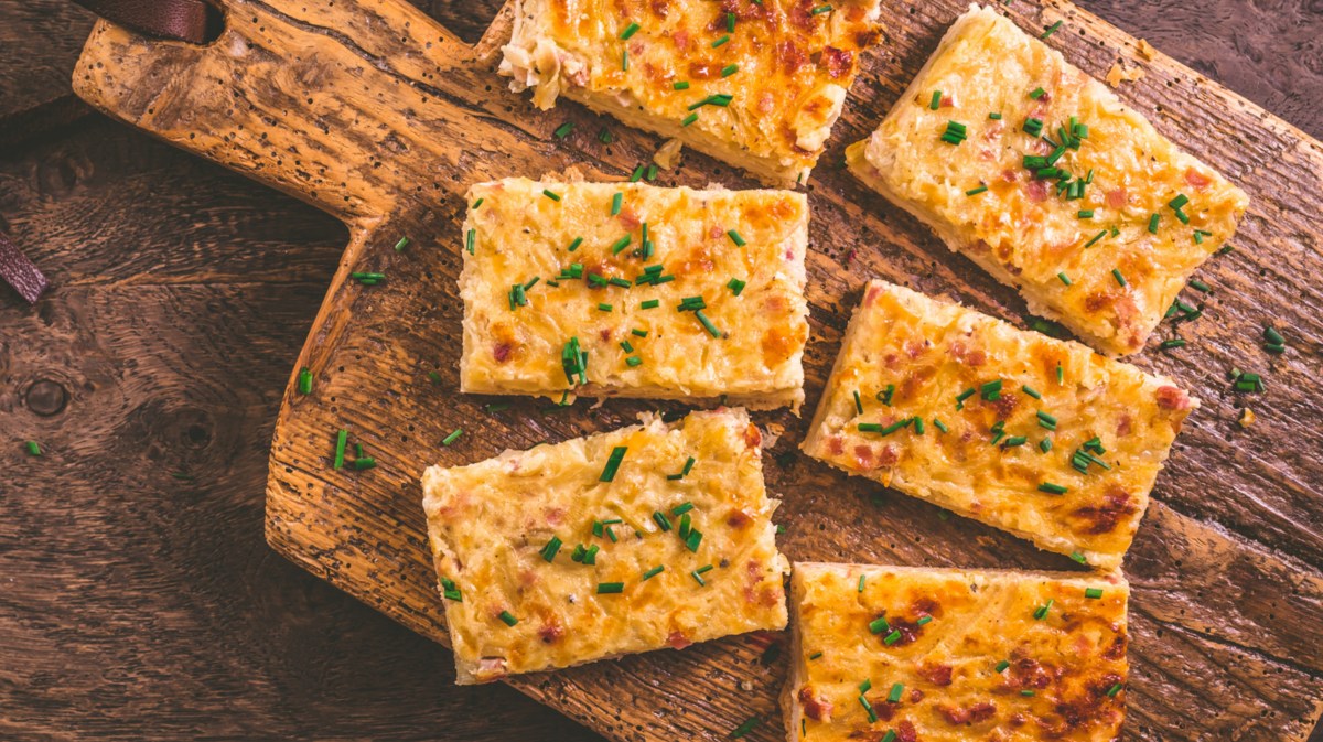 Zwiebelkuchen auf einem Holzbrett.