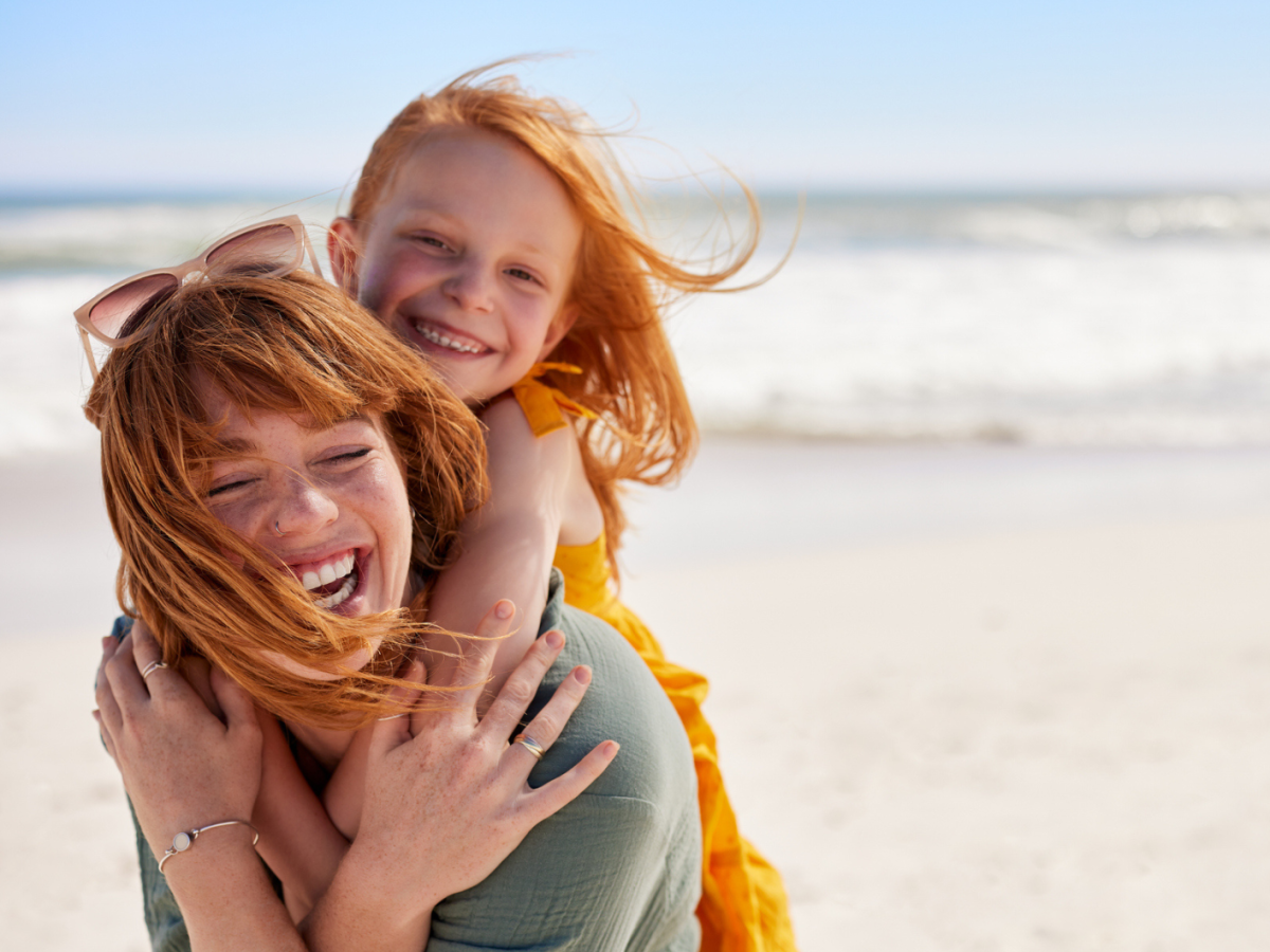 Mutter hebt Tochter auf dem Rücken und laufen am Strad herum
