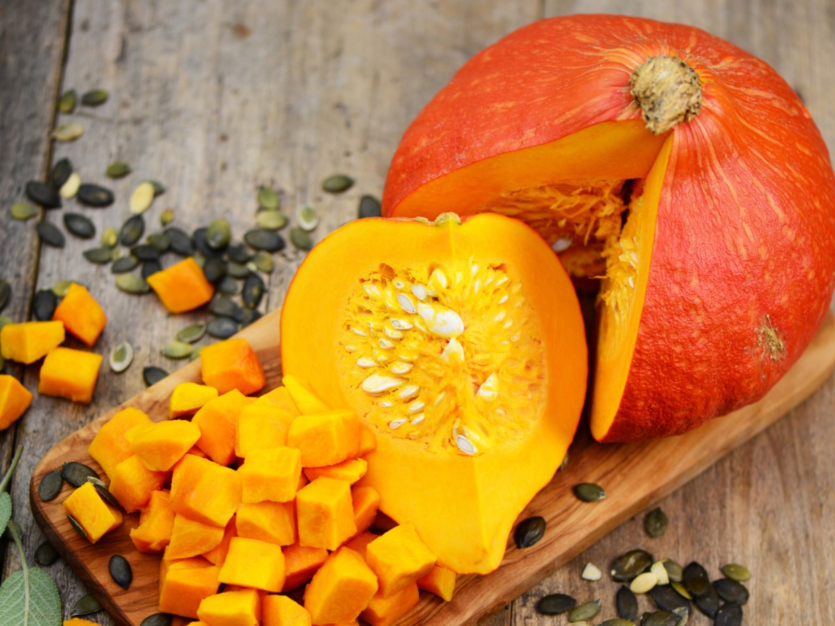 Hokkaido K&uuml;rbis aufgeschnitten auf Holzbrettchen.