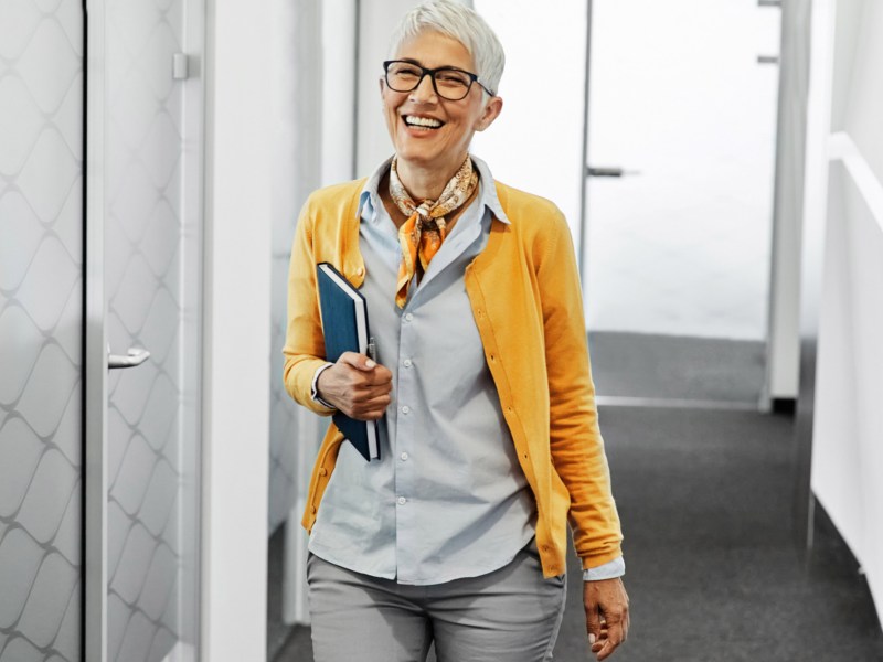 Frau mit grauen kurzen Haaren ist auf der Arbeit in Büro.