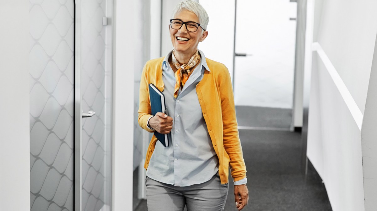 Frau mit grauen kurzen Haaren ist auf der Arbeit in Büro.