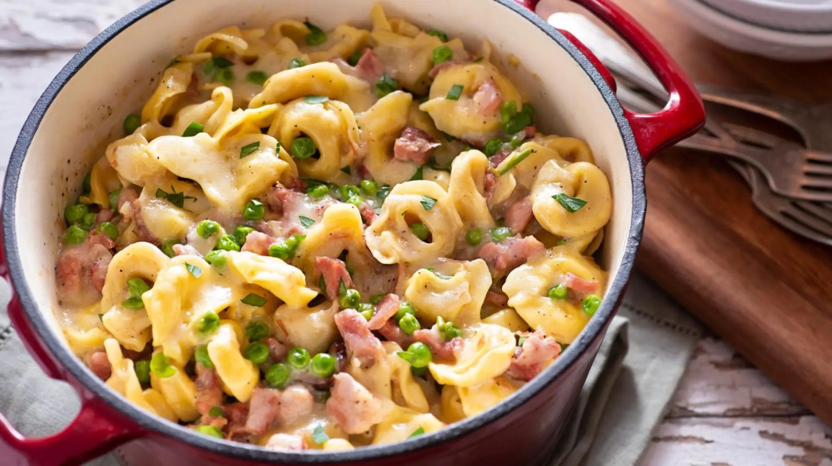 Schinken-Kaese-Tortellini mit Erbsen im Topf.