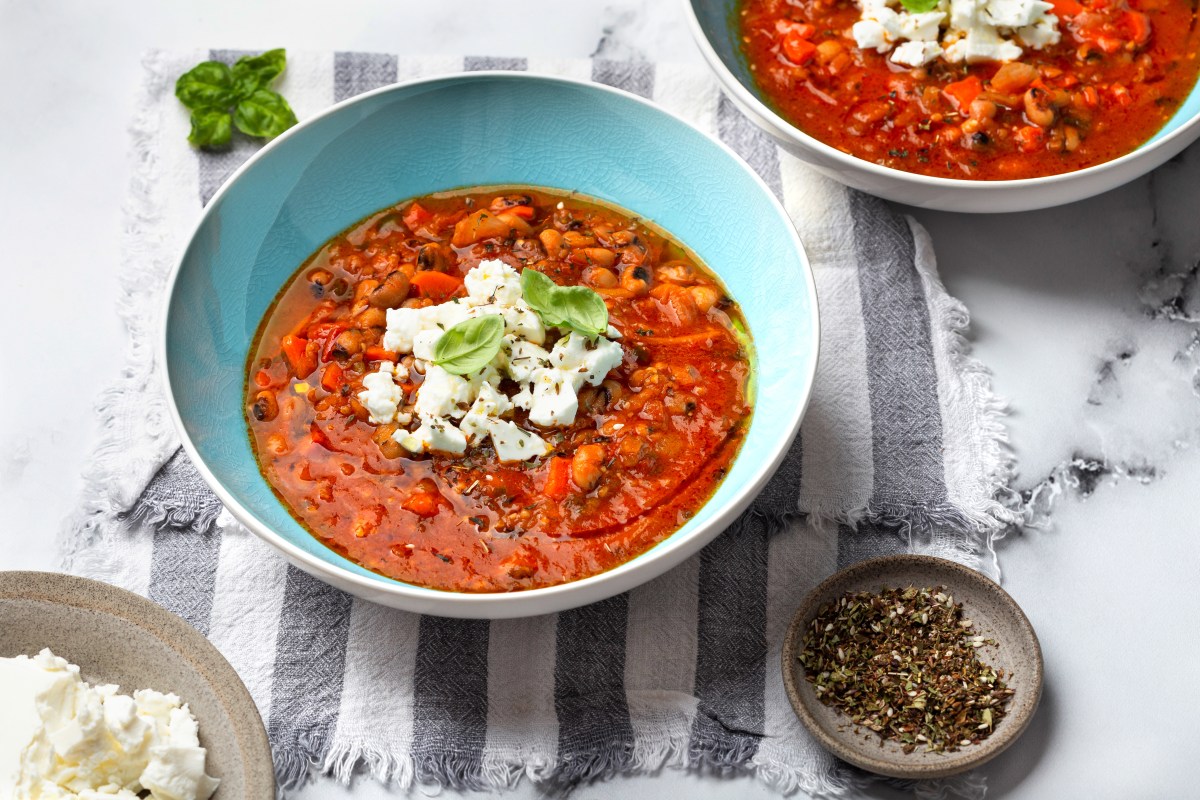 Gyros Suppe mit Deko in blauer Schüssel auf einem gestreiften Tuch