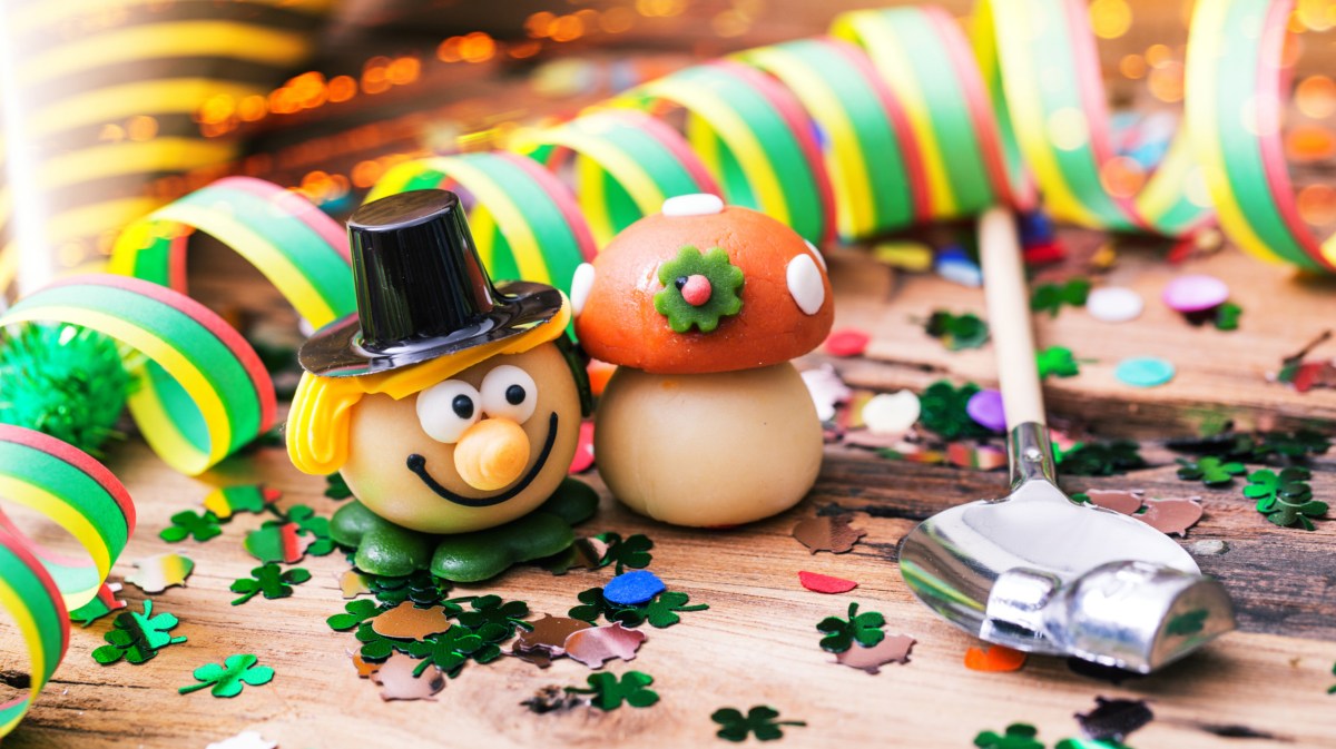 Silvesterdeko und Utensilien zum Bleigießen auf einem Tisch.