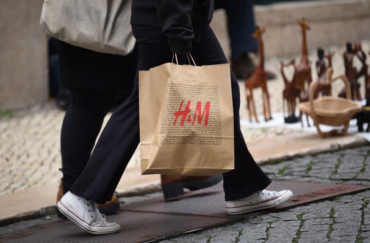 Frau, die gerade bei H&M eingekauft hat und jetzt eine Shoppingtüte trägt.