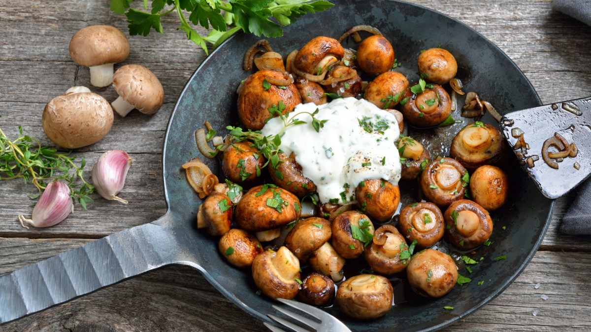 Champignons mit Knobisosse in einer Pfanne.