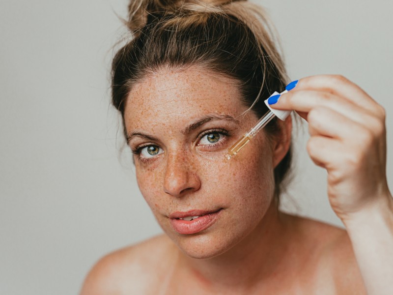 Frau tr&auml;gt Serum auf Gesicht auf