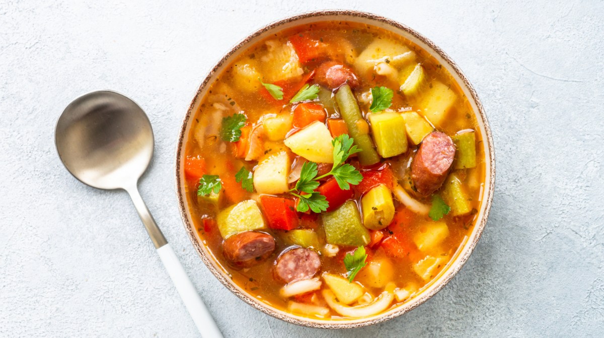 Suppe mit Mettwürstchen, Kartoffeln und Tomaten.