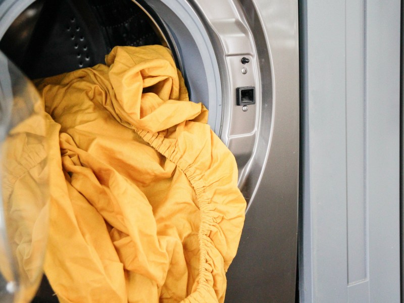 Gelbe Bettwäsche in Waschmaschine