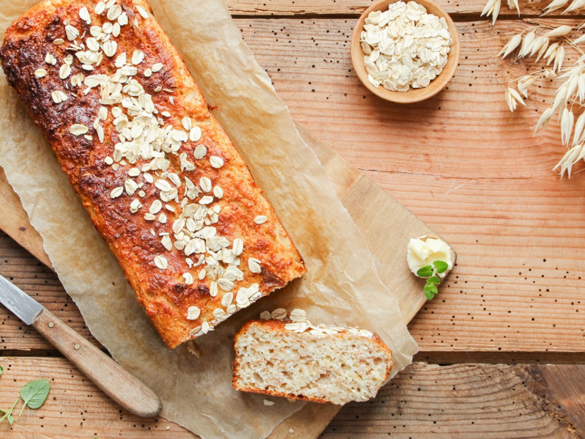 Selbstgebackenes Haferflocken-Quark-Brot auf Holztisch.