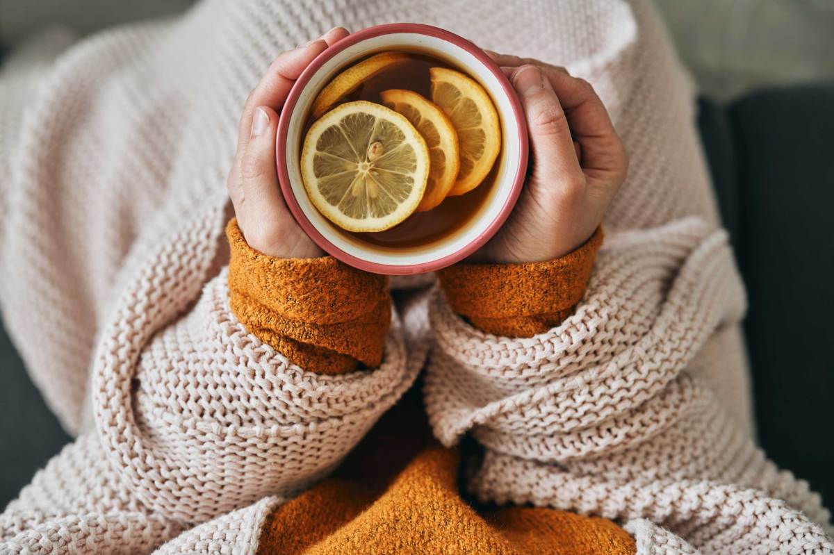 Draufsicht auf eine Frau, die eine Tasse heißen Tee hält