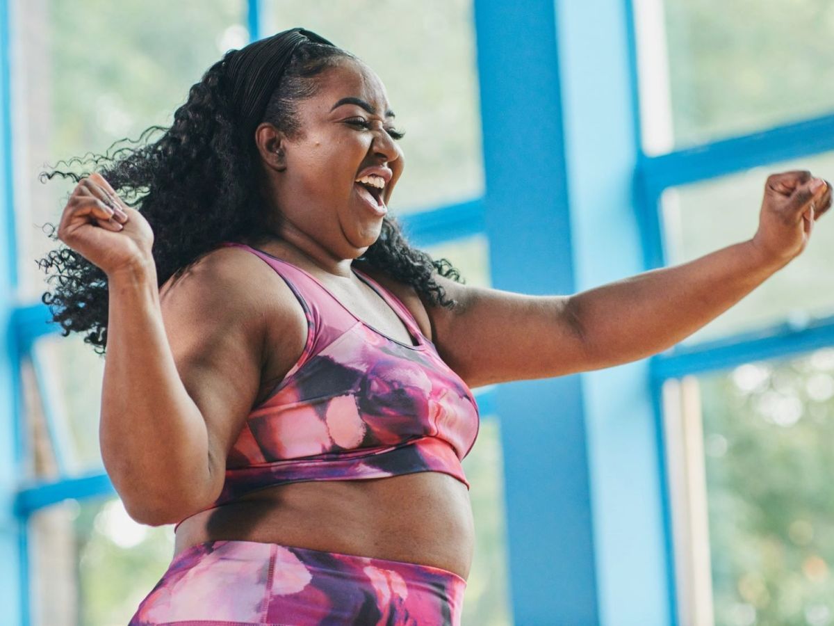 Frau lacht glücklich während sie Dance Fitness macht.