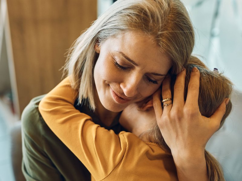 Mutter tr&ouml;stet ihr Kind, dr&uuml;ckt es fest an sich.